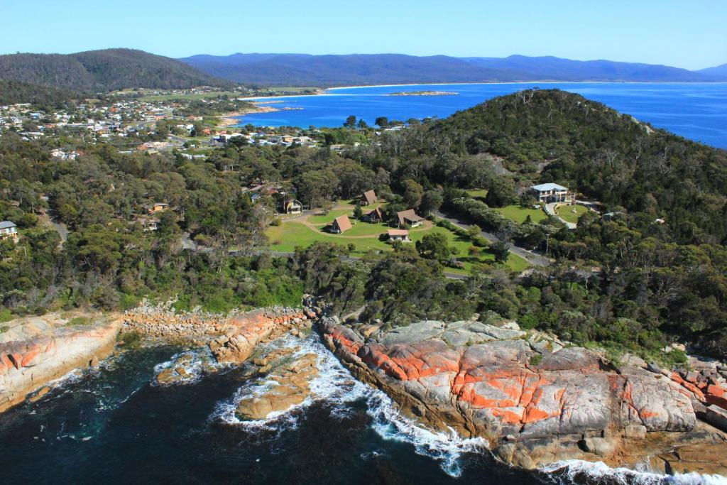 an aerial view of the rocky cliffs of the ocean at Bicheno by the Bay in Bicheno