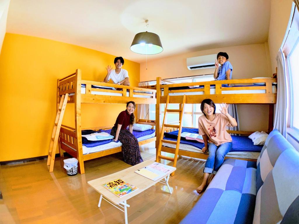 a group of people in a room with bunk beds at ルルルあたご 3〜6名に最適 家族＆グループ向き ゆったり1Rアパートタイプ in Kochi