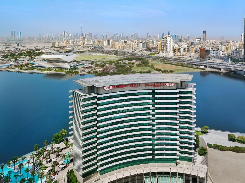 Crowne Plaza Dubai Festival City في دبي: اطلالة جوية على مبنى طويل بجانب تجمع المياه