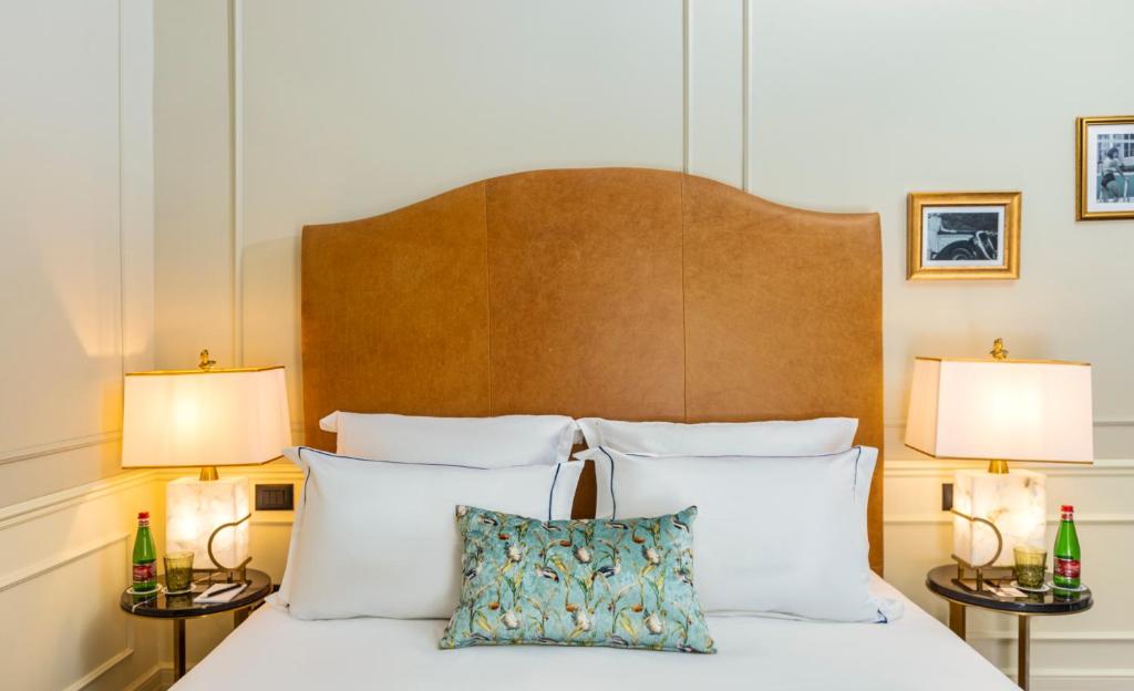 a bedroom with a bed with white pillows and two lamps at Villa Brown Tel-Aviv, a member of Brown Hotels in Tel Aviv