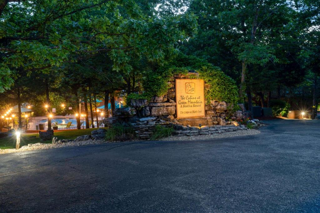 a sign in front of a stone wall with trees at Cabins at Green Mountain, Trademark Collection by Wyndham in Branson