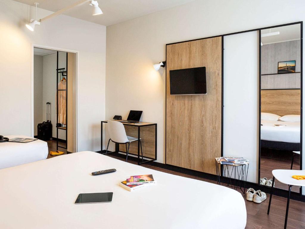 ein Hotelzimmer mit einem Bett und einem TV in der Unterkunft Ibis Centre Millau in Millau