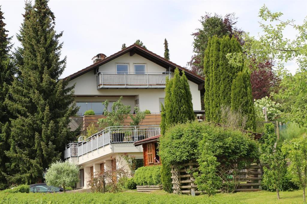 ein großes Haus mit einem Balkon und Bäumen in der Unterkunft Ferienapartments Klatte in Wangen im Allgäu