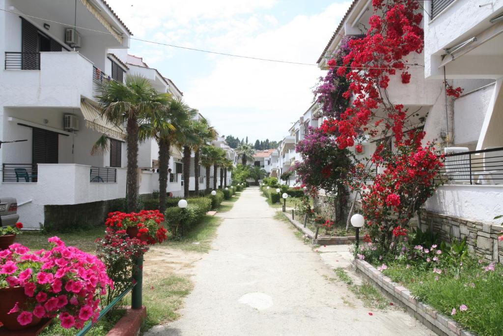 a street in a town with flowers on the buildings at Villa Repas in Pefkochori