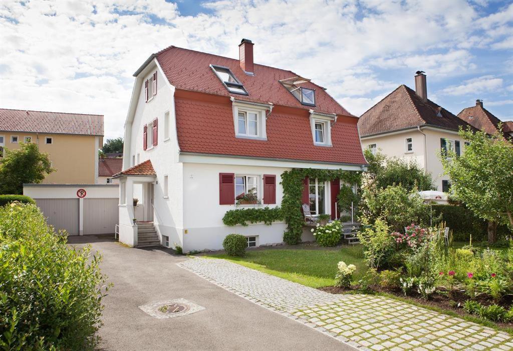 une grande maison blanche avec un toit rouge dans l'établissement Ferienwohnung Beletage, à Wangen im Allgäu