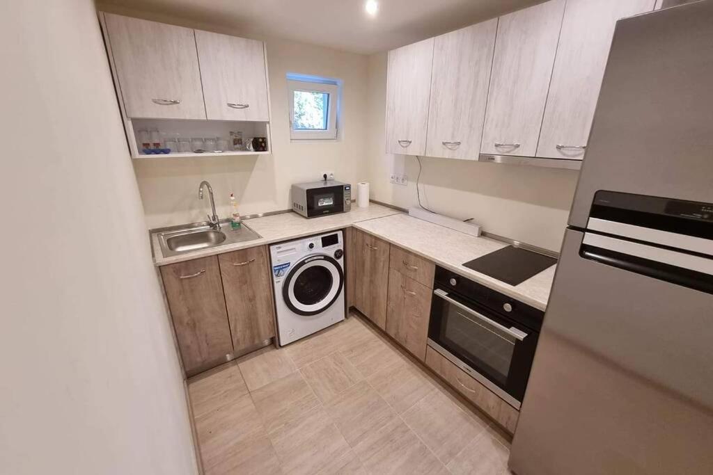 a small kitchen with a washing machine and a washer at Guest House 59 in Varna City