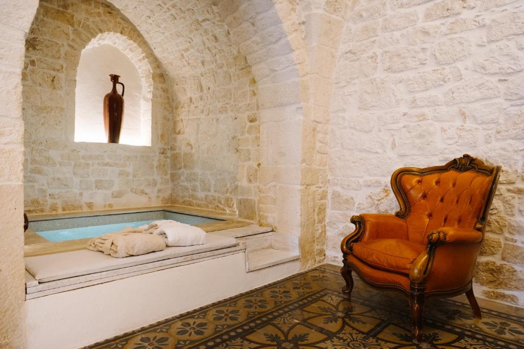 een bad in een kamer met een stoel en een raam bij Casa Sotto l'Arco in Ceglie Messapica
