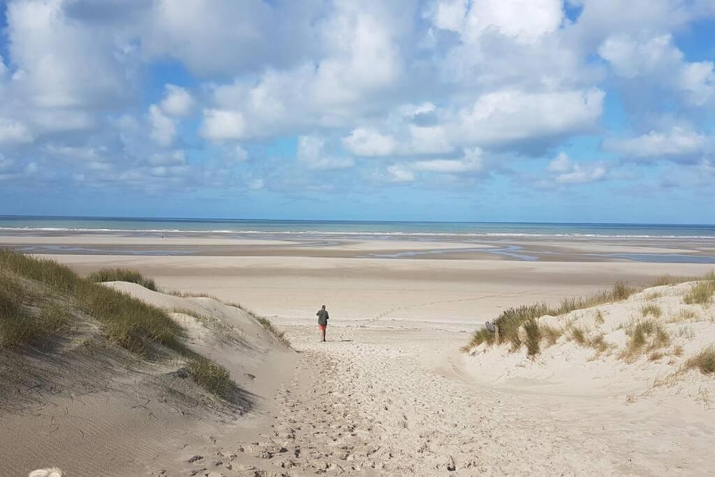 une personne se promenant sur une plage de sable près de l'océan dans l'établissement La Cabane des Dunes à Fort-Mahon Plage, à Fort-Mahon-Plage