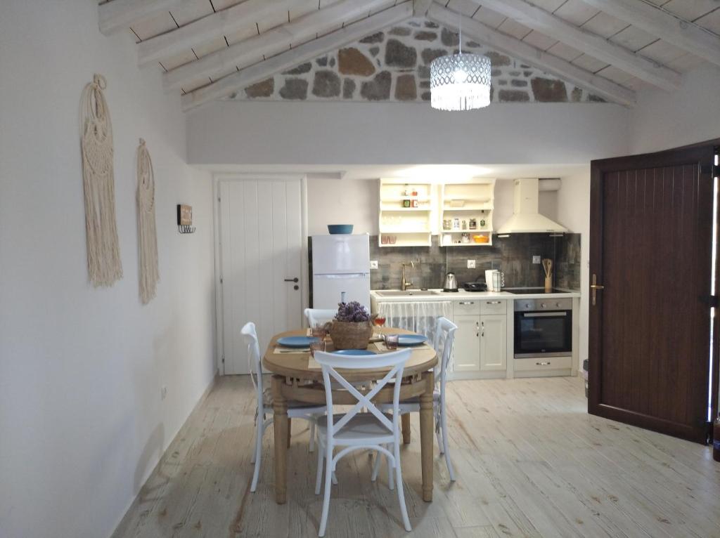 uma cozinha com uma mesa e cadeiras e um frigorífico em Paliokaliva Home em Roussopoúlion