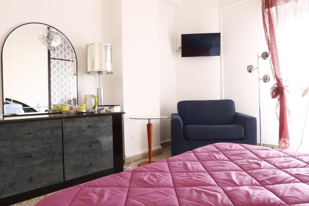 1 dormitorio con cama, espejo y silla en Casa di Nonna Signorina en Giarre