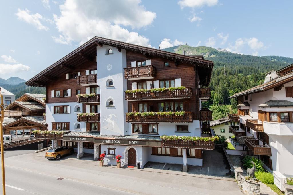 ein Gebäude mit Balkonen an der Straßenseite in der Unterkunft Hotel Steinbock in Klosters