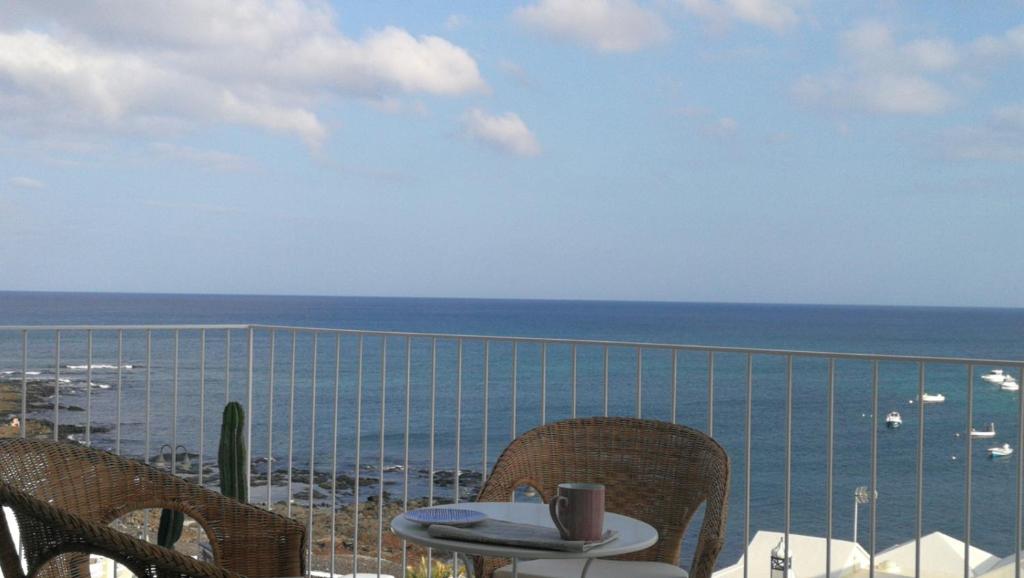 una mesa y sillas en un balcón con vistas al océano en Sargo, en Punta Mujeres