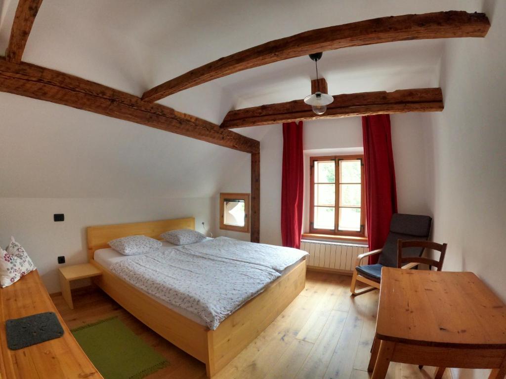 a bedroom with a large bed and a table at Juvanova hous - rooms in Luče