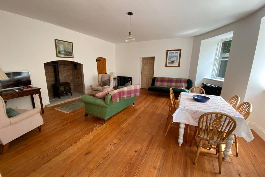a living room with a table and chairs and a couch at The Courtyard Apartment, Strangford in Strangford