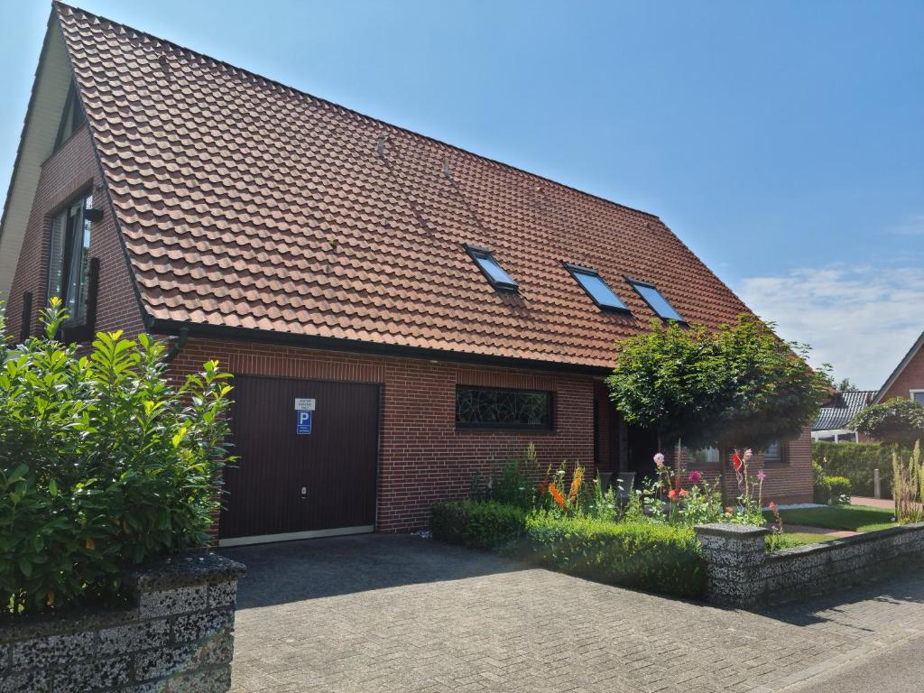 a brick house with a garage and some plants at Ferienwohnung Haus Fischer in Langwedel