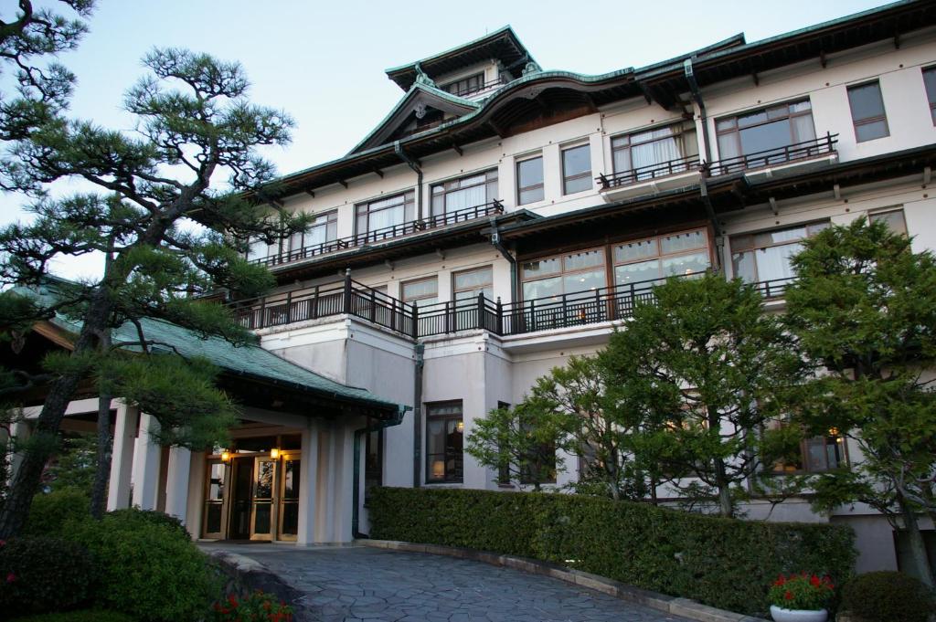 a large white building with trees in front of it at Gamagori Classic Hotel in Gamagōri