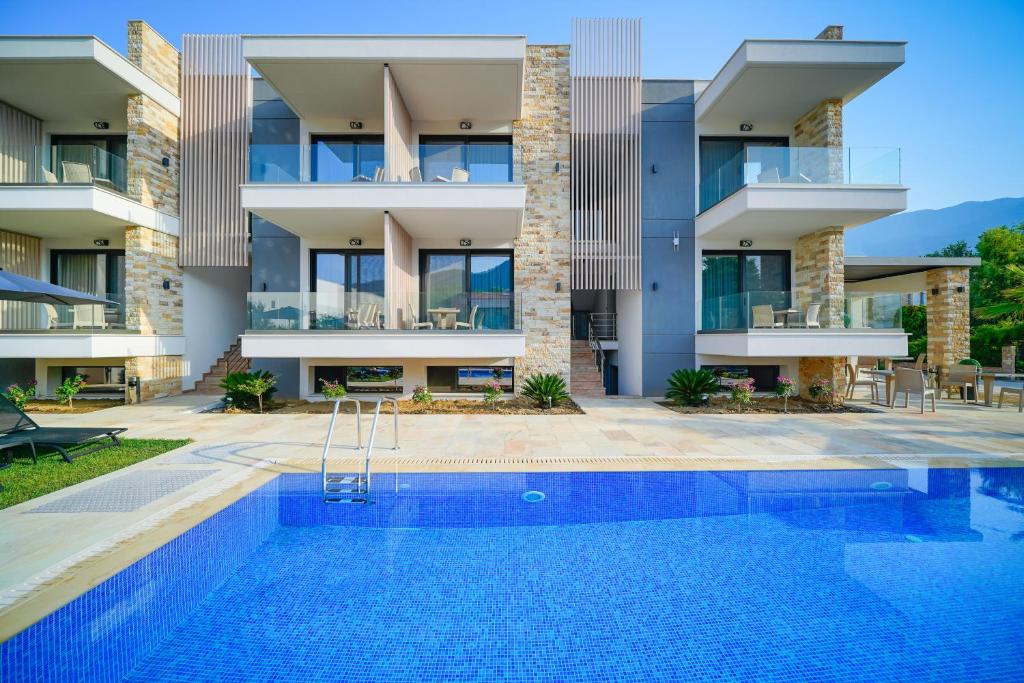 an apartment building with a swimming pool in front of it at Tereza Golden in Chrysi Ammoudia