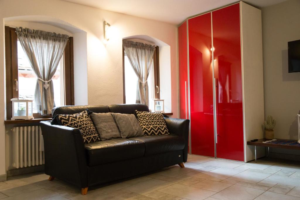 a living room with a couch and a red door at Maison Poppy in Aosta