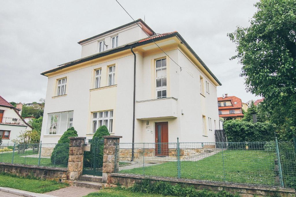 una vecchia casa bianca con una recinzione di fronte di Vila Šumná a Luhačovice