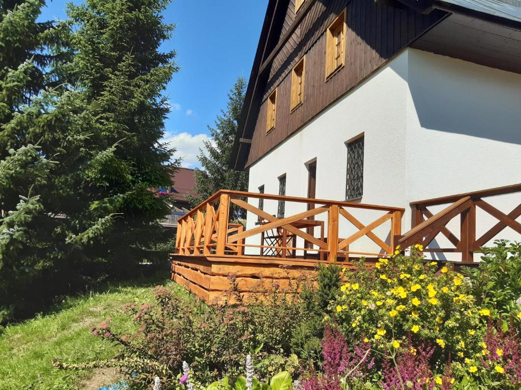 een huis met een houten terras aan de zijkant bij Apartmán U Lišek in Janov nad Nisou