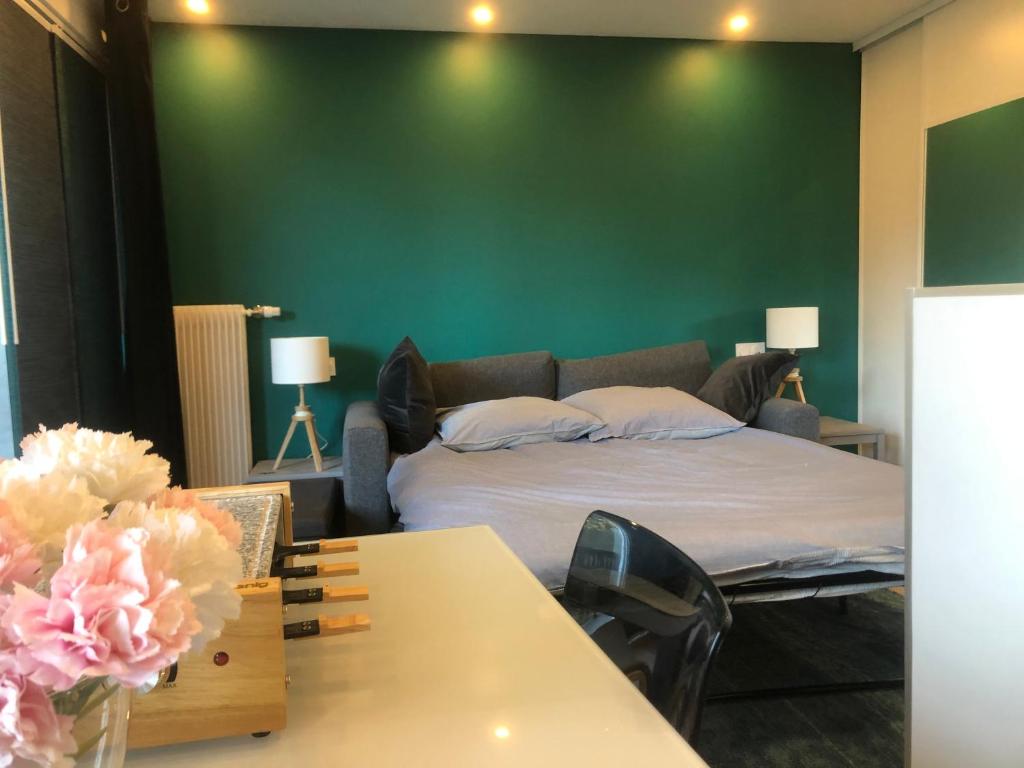 - une chambre avec un lit et un mur vert dans l'établissement Boost Your Immo Les Deux Alpes Le Midi 502, à Les Deux Alpes