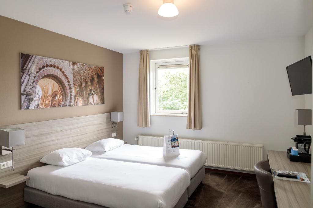 Postel nebo postele na pokoji v ubytování Fletcher Kloosterhotel Willibrordhaeghe