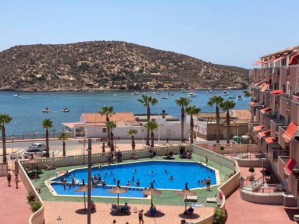 a view of a swimming pool in a resort with a body of water at Apartament Claudia I in Puerto de Mazarrón