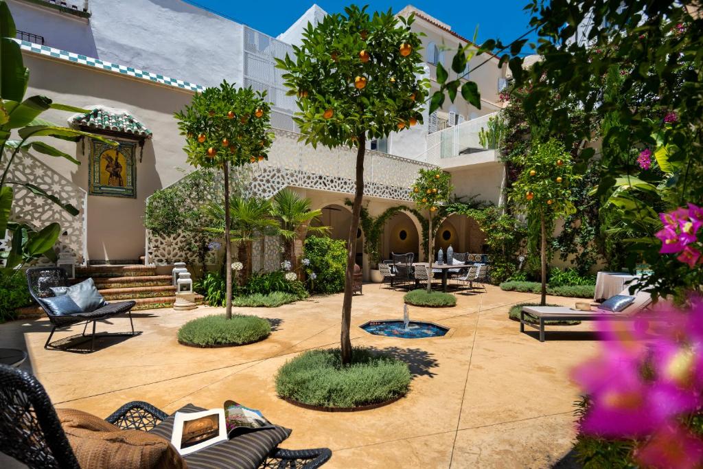 a courtyard with furniture and trees in a building at Pájaro Rebelde in Seville