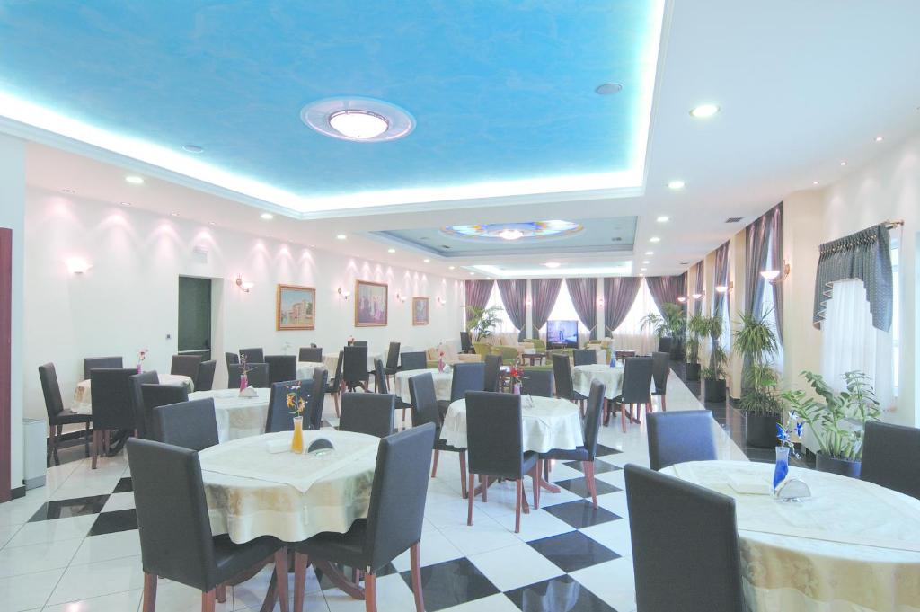 un restaurant avec des tables et des chaises et un plafond bleu dans l'établissement Hotel Platon, à Athènes