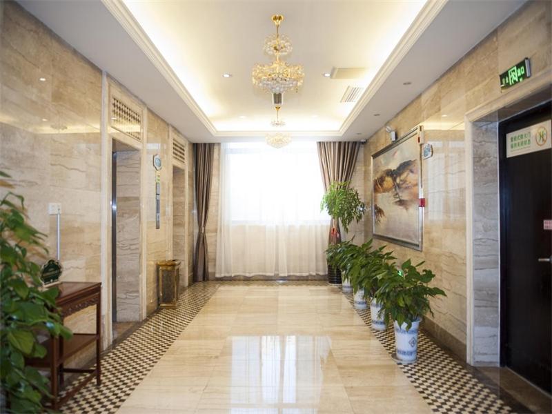 un couloir avec des plantes en pot dans un bâtiment dans l'établissement Vienna Hotel Jiangyin Qishan Road, à Jiangyin