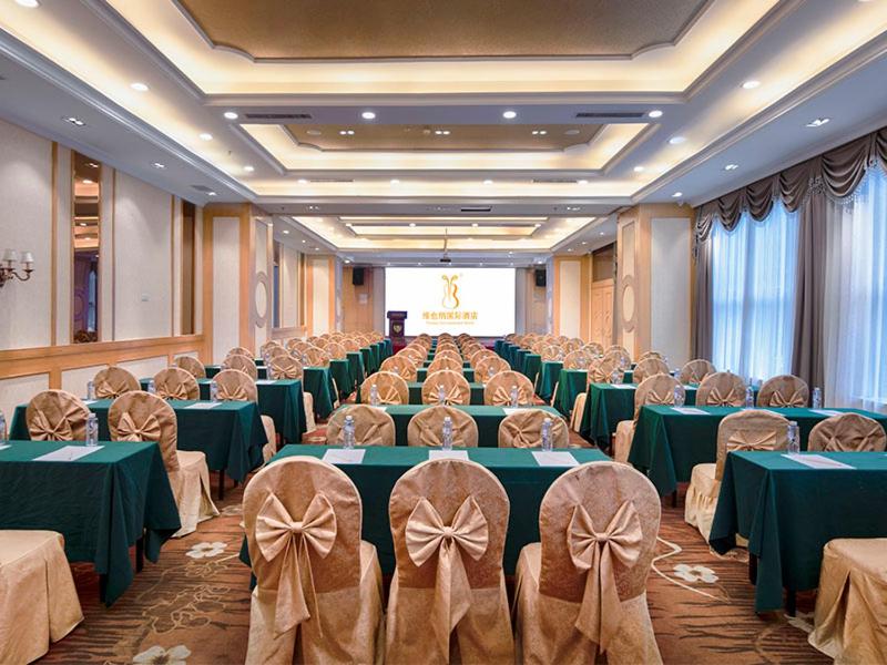a banquet hall with green tables and chairs and a projector at Vinenna International Hotel Shenzhen shajing in Bao'an