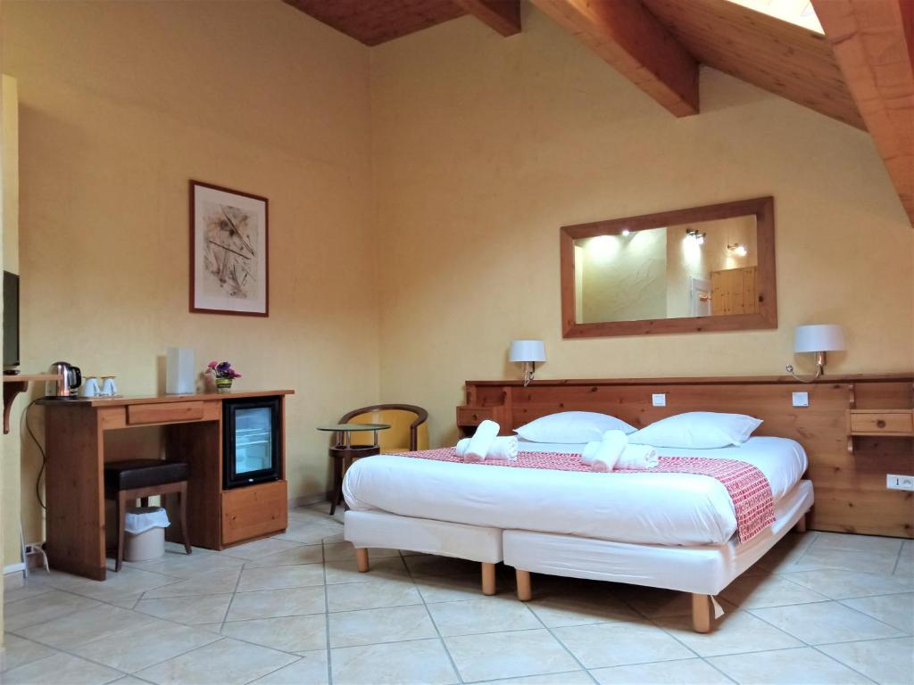 a bedroom with a large bed and a television at Hôtel Mont Thabor Serre Chevalier in La Salle-les-Alpes
