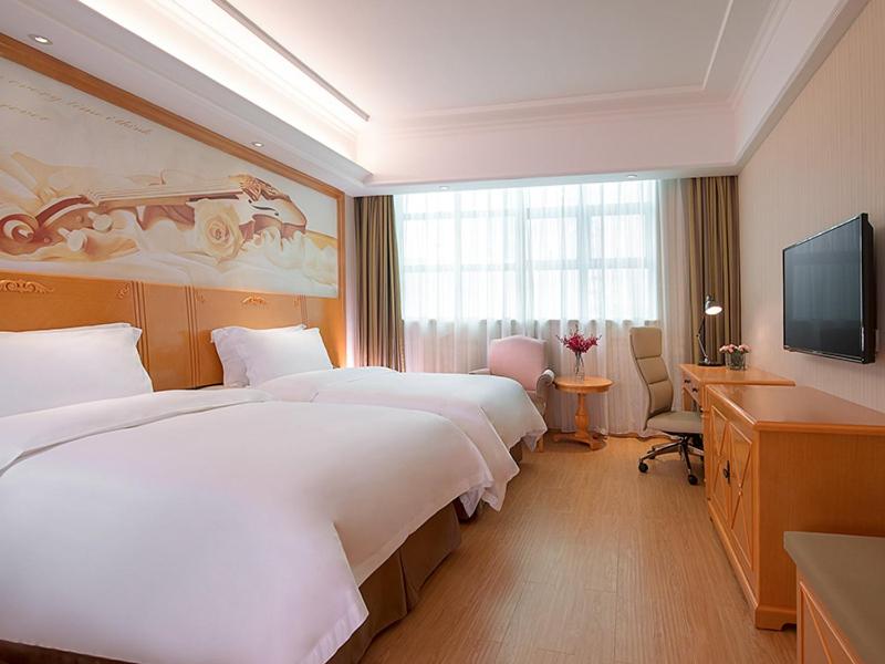 a hotel room with two beds and a television at Vienna 3 Best Hotel Shenzhen Airong Road in Shenzhen
