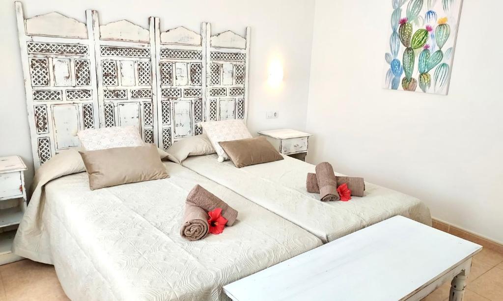 2 camas en una habitación con almohadas rojas. en Tamarindo 27 pool front next to the dunes, free WIFI, en Corralejo