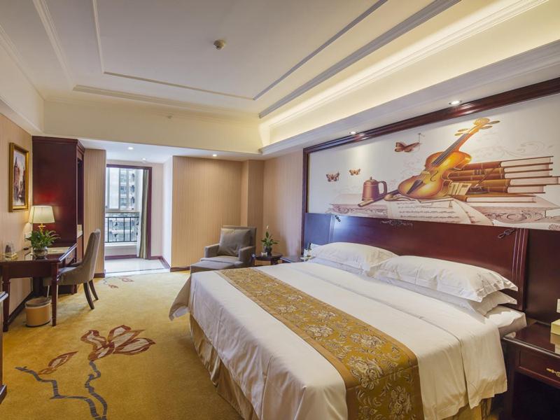 a hotel room with a large bed and a desk at Vienna Hotel Xi'an International Exihibition Center in Xi'an