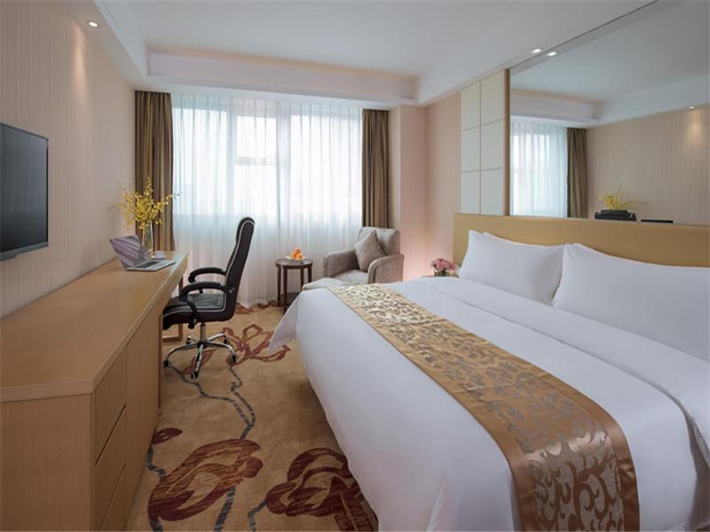 Habitación de hotel con cama grande y escritorio. en Vienna Hotel Dongguan ChangAn Wanda Plaza, en Dongguan