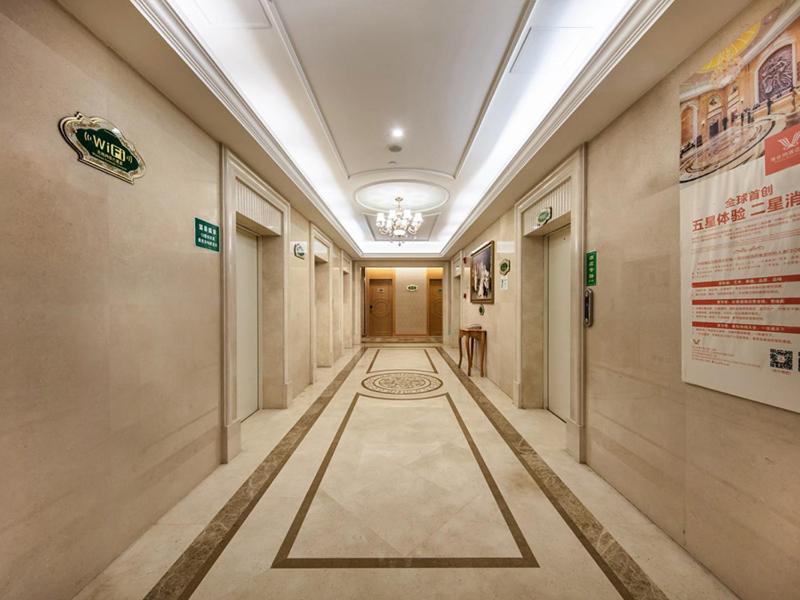 un pasillo en un edificio con un pasillo largo con una señal en Vienna International Hotel Fuzhou Cangshan Wanda en Fuzhou