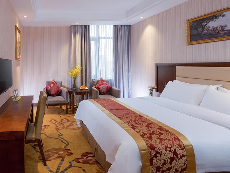 Ένα ή περισσότερα κρεβάτια σε δωμάτιο στο Vienna Hotel Shenzhen Gongming Bus Station