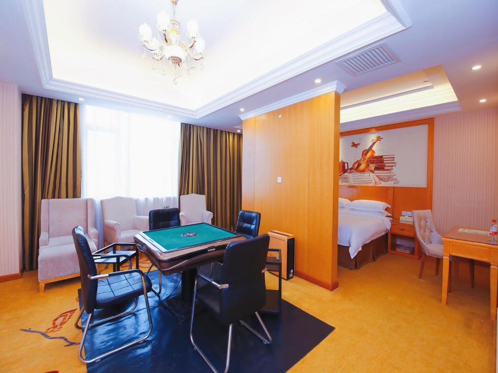 a hotel room with a ping pong table and a bedroom at Vienna Hotel Shenzhen Longgang Ainan Road in Longgang