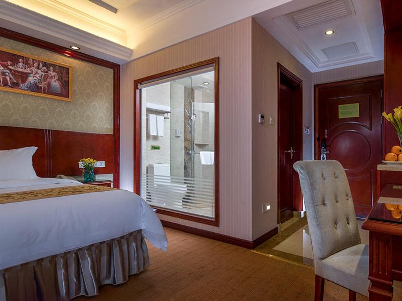 Un dormitorio con una cama grande y una ventana en Vienna Hotel Guangzhou Airport 2 en Cantón