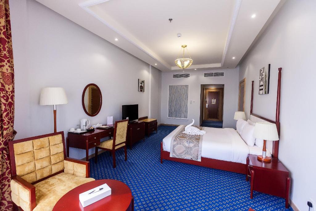 a hotel room with a bed and a desk at Red Castle Hotel in Sharjah