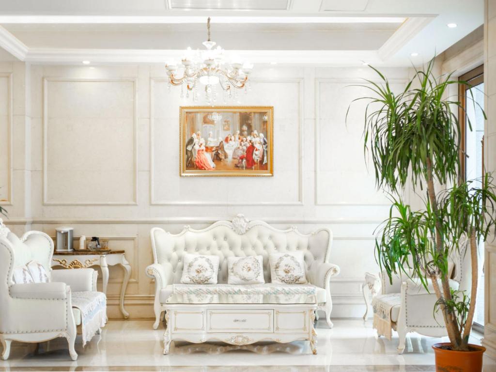 a living room with a white couch and two chairs at Vienna Hotel Wuhan Yellow Crane Tower in Wuhan