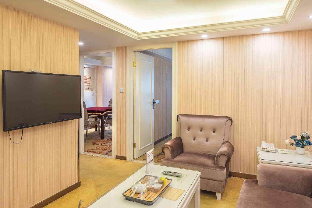 a living room with a chair and a flat screen tv at Vienna Hotel Guangxi Nanning International Convention and Exhibition Center in Nanning