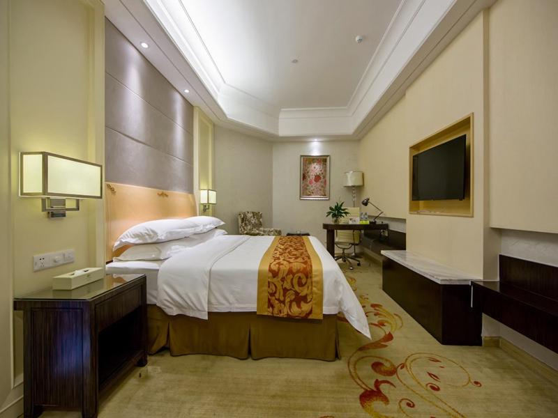 Habitación de hotel con cama y TV en Vienna Hotel Jiangmen Heshan Huamao en Heshan