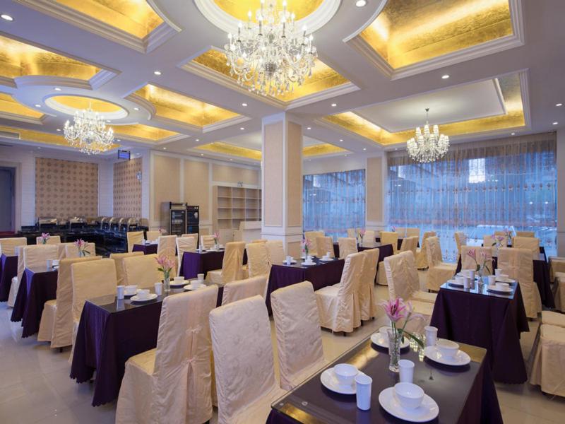 a banquet hall with tables and chairs and chandeliers at Vienna Hotel Meizhou Xingning District Plaza in Libei