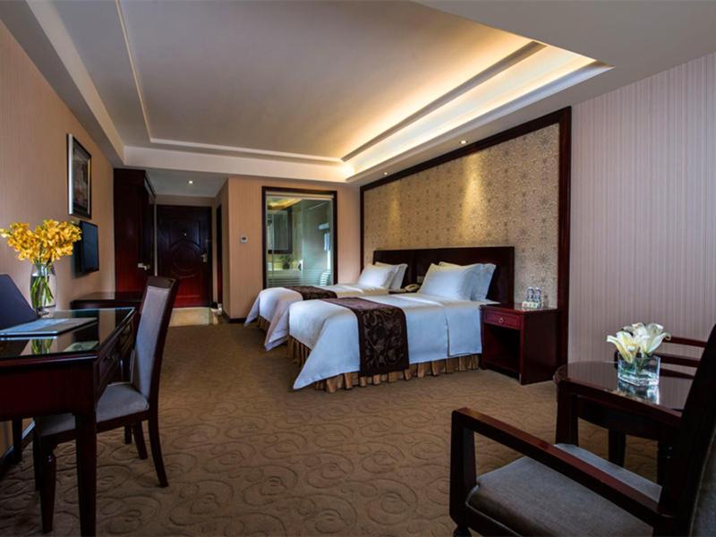 a hotel room with two beds and a desk at Vienna Hotel Shenzhen Fenghuang Road in Shenzhen