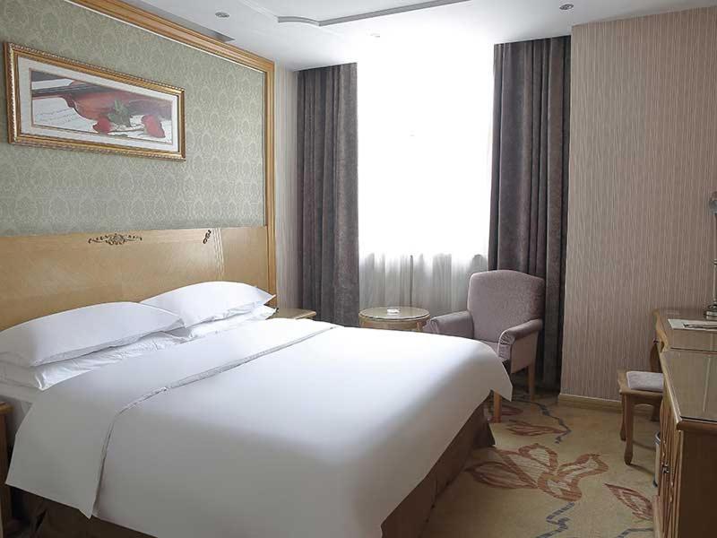 Tempat tidur dalam kamar di Vienna Hotel Suzhou Luokou Metro Station