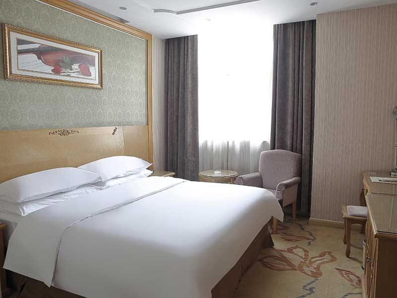 a large white bed in a hotel room at Vienna Hotel Suzhou Luokou Metro Station in Suzhou