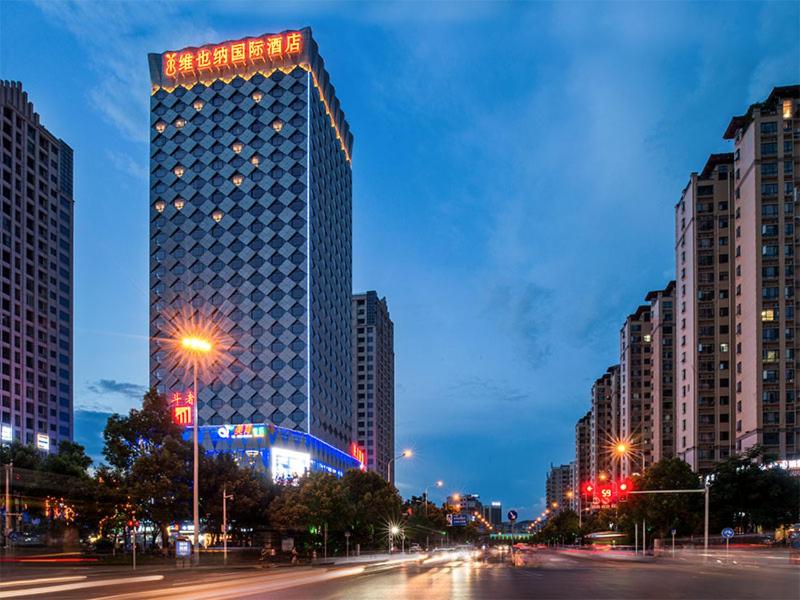 a tall building in a city at night at Vienna International Hotel Hunan Chenzhou Qingnian Avenue in Chenzhou