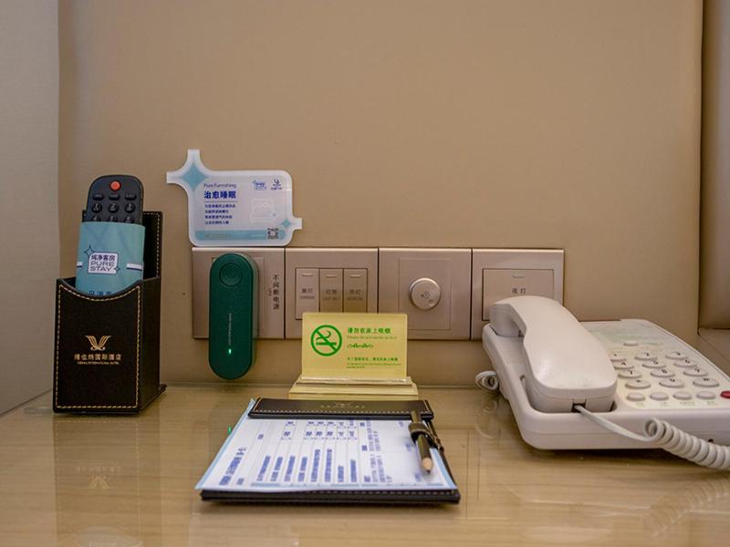 um quarto de hospital com uma máquina e um telefone em Vienna International Hotel Hangzhou East Railway Station em Hangzhou